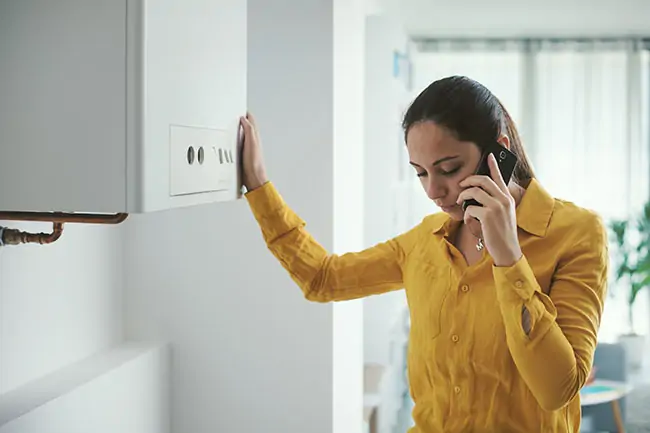 Woman on phone to engineer about broken boiler