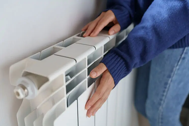 Woman feeling the heat from a radiator