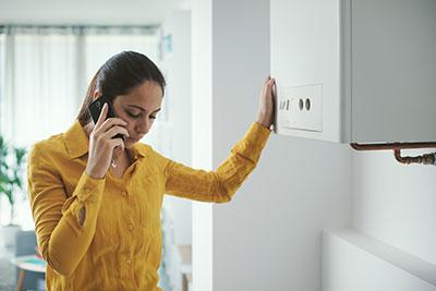 Woman calling engineer to help with broken boiler